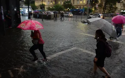 Pedestres se defendendo de chuva forte em São Paulo. Foto: Rovena Rosa / Agência Brasil